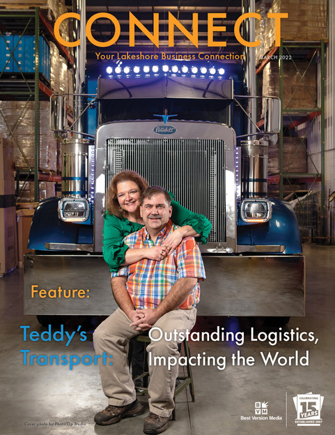 The cover of the March 2022 issue of CONNECT magazine. Two people dressed in bright colors hug in front of a huge blue truck. Text reads: "Teddy's Transport: Outstanding Logistics, Impacting the World"